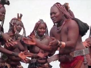 Африканська himba жінки танець і гойдалки їх відвислий цицьки навколо